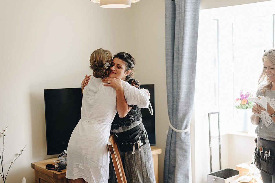 bride hugging the hairstylist