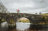 Bride and groom holding colourful umbrellas on Two Bridges Hotel bridge over the river.